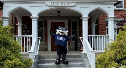 WildEcat waving in front of Smith Hall